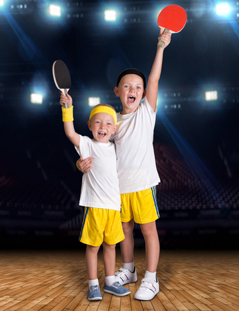 Two brothers play tennis in the sports hall.Champions.の写真素材