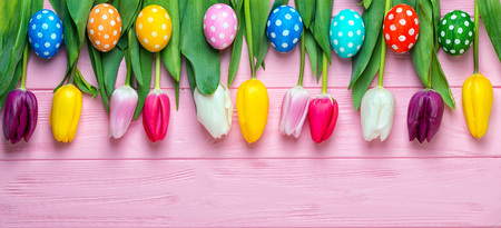 Easter eggs with colorful tulips on a wooden background, easter holiday concept.の写真素材