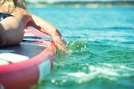 Young sexy woman swimming on paddle board.Water sports, active lifestyle.の写真素材