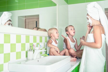 Mother and children make a face mask in the morning.The boys joke with mom. Beauty treatments for...