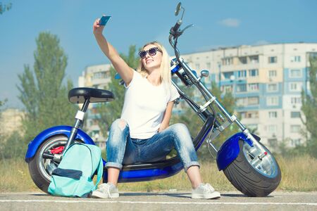 Girl biker sits on a motorcycle and photographed. Relax after the trip.の写真素材