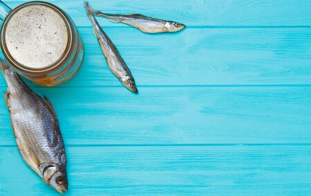 Mug of beer with salted fish on a wooden background.