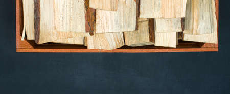 Wooden box with firewood on a black backgroundの写真素材