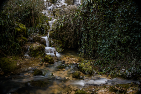 Roquefort Cascades France frozen waterfall in lush forest in Franceの写真素材