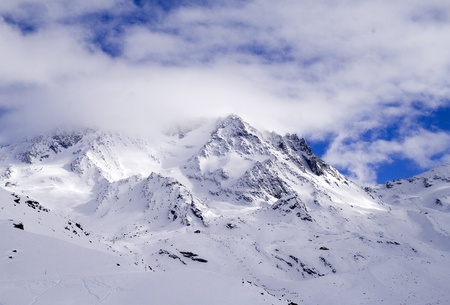 Low clouds cover the mountain peaks covered with snowの写真素材