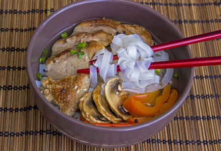 The stewed noodles with duck meat and vegetables on bamboo backgroundの写真素材