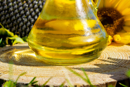 oil in jars and sunflower on wooden backgraundの写真素材