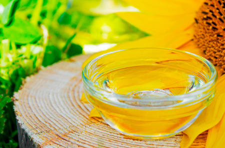 oil in jars and sunflower on wooden backgraundの写真素材