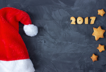 background with Santa's cap and baked gingerbread text 2017 on the concrete background. creative ideaの写真素材