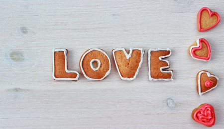 heart shape and word LOVE valentine homemade cookies on light wooden backgroundの写真素材
