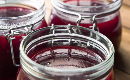 Close Up View Of Jars With Sweet Tasty Yummy Red Jam on wooden background
