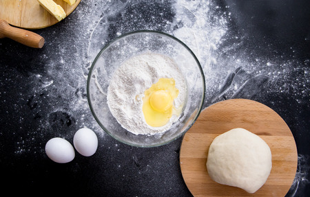 separating the yolk from the egg white. woman making dough. top viewの写真素材