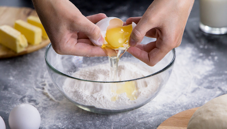 woman separating the yolk from the egg white. woman making dough
