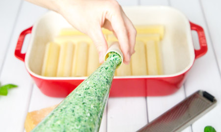 closeup of Spinach and cheese cannelloni preparation : Stuffing the cannelloni with the spinach and cheese fillingの写真素材