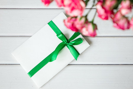 greeting card with pink roses on wooden background. Top view with space for your greetingの写真素材