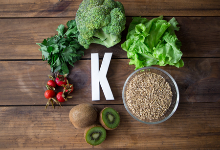 Foods highest in Vitamin K and letter K on a wooden board. Healthy eating. Top viewの写真素材