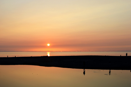 Sunset over the sea, and fishermen catch fishの写真素材