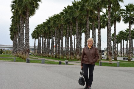 woman walks in a park with palm treesの写真素材