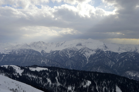 Mountain. The mountains, the snow, through the cloudsの写真素材