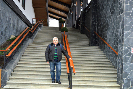 A man stands on the staircase that leads to the lifts to the mountainsの写真素材