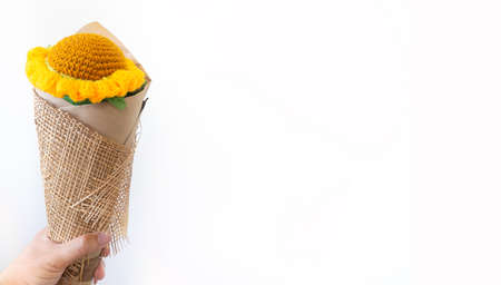 The man's handheld the orange sunflower forward. A fake flower Forgiving as a gift to loved ones on the day of the month of loveの写真素材