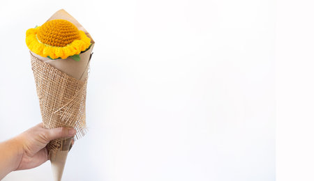 The man's handheld the orange sunflower forward. A fake flower Forgiving as a gift to loved ones on the day of the month of loveの写真素材
