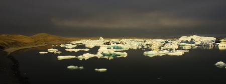 Icebergs on Jokulsarlon glacial lagoon with overcast sky in late afternoon.の写真素材