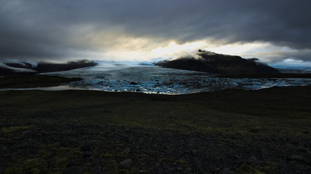Fjallsarlon glacial lagoon with floating icebergs and glacier and mountains behind with overcast sky. Southern Iceland.の写真素材