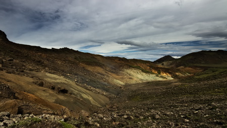 A small valley with tiny ârainbow mountainsâ in the distance with volcanic soil around on hiking trail Reykjavegur in backcountry of Iceland not far from ReykjavÃ­k in Reykjanes peninsula.の写真素材