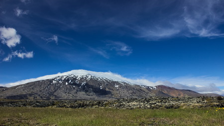 Clouds rolling over Snaefellsjokull glacier on a sunny day on Snaefellsnes peninsula in Western Iceland.の写真素材