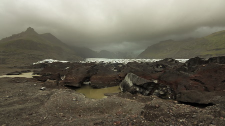 End of tongue of Svinafellsjokull glacier with mountains in background and overcast sky in Vatnajokull national park, Southern Iceland.の写真素材