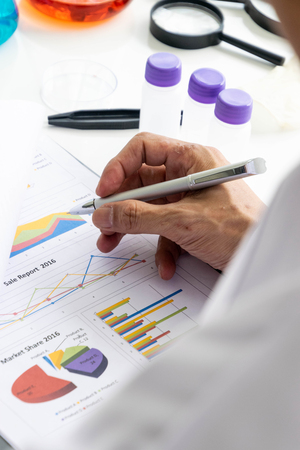 Scientists are writing reports on a table filled with beaker.の写真素材