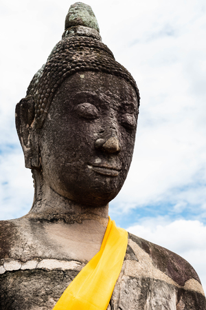 Close-up of ancient stone Buddha statue at Wat Mahathat in Ayutthaya Historical Park, a World Heritage Site located in Thailand.の写真素材