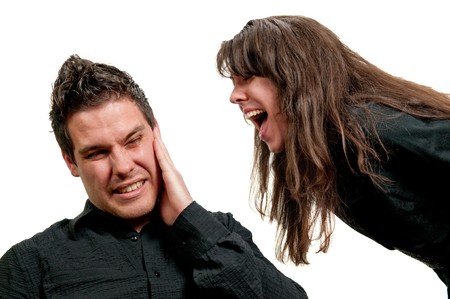 Girl shouting in guy's ear isolated on white background