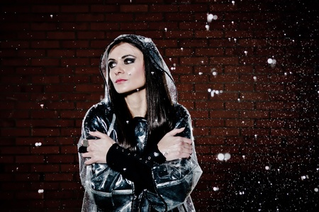 Woman standing in the rain with her arms crossed from cold