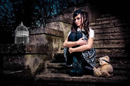 Adolescent lolita schoolgirl sitting on stairs looking sadの写真素材