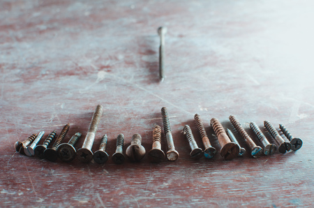 On the old table are screws of different sizes, texture backgroundの写真素材