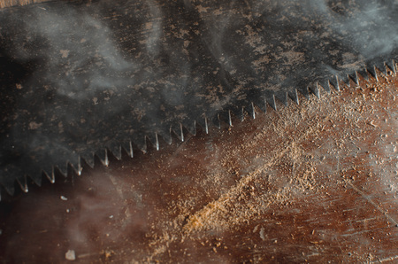 a hacksaw on the old table background texture lies