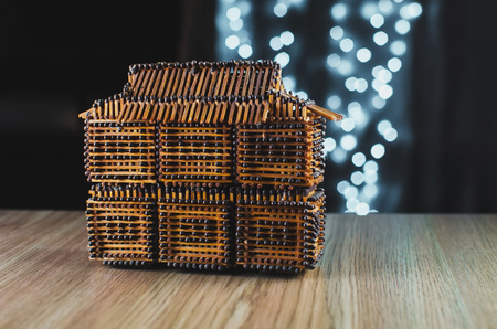 On the table is a house of matches, behind garlands, bokeh beautiful Christmasの写真素材