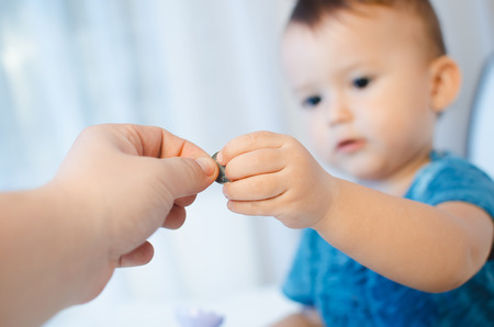 The child takes or gives money in the hand of the fatherの写真素材