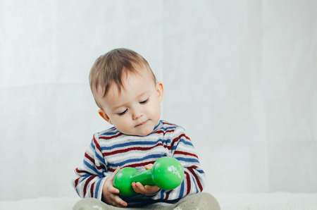 The child is involved in sports, fitness lifting dumbbellの写真素材