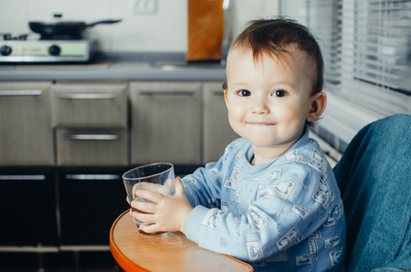 Portrait of boy drinking glass of water isolated in whiteの写真素材
