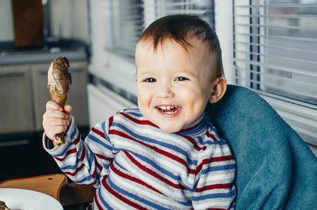 Child holding a chicken and laughs before you eat itの写真素材