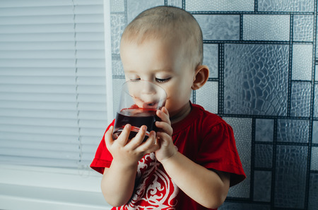 Small short-haired boy with a glass of fresh juiceの写真素材