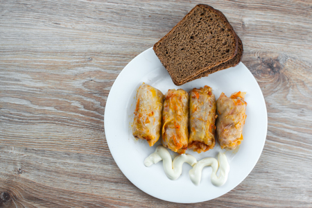 stuffed cabbage is a traditional Ukrainian meals, stewed cabbage leaves stuffed with ground meat and rice with sour cream with sliced cucumbersの写真素材
