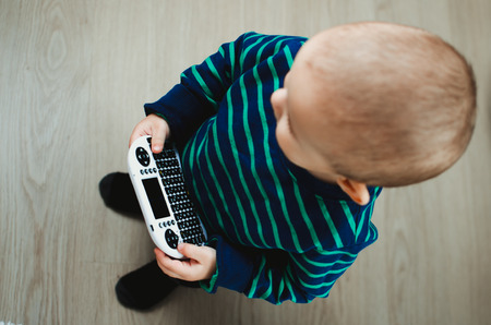 the child is playing, is dealing with a mini-keyboard for computer equipment