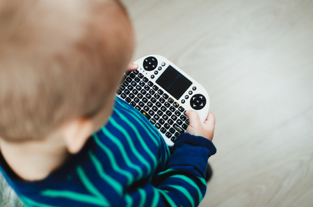 the child is playing, is dealing with a mini-keyboard for computer equipment