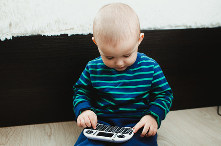 the child is playing, is dealing with a mini-keyboard for computer equipment