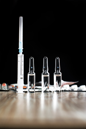 On the table there are ampoules, next different pills,drugs and medicationsの写真素材