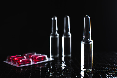 On the table there are ampoules, next different pills,drugs and medicationsの写真素材